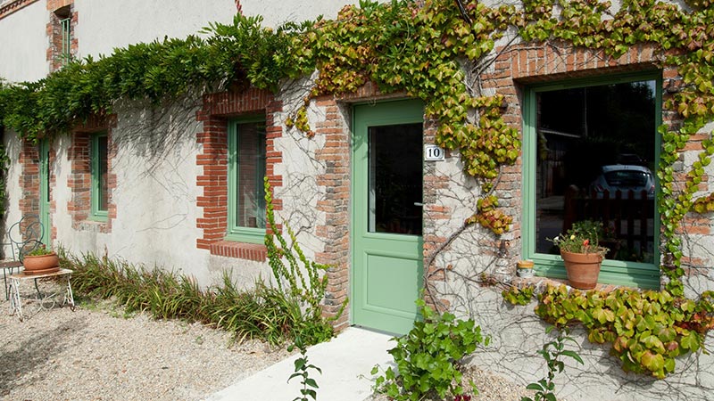 porte d'entrée verte avec vitrage accordée aux fenêtres pour une maison rurale